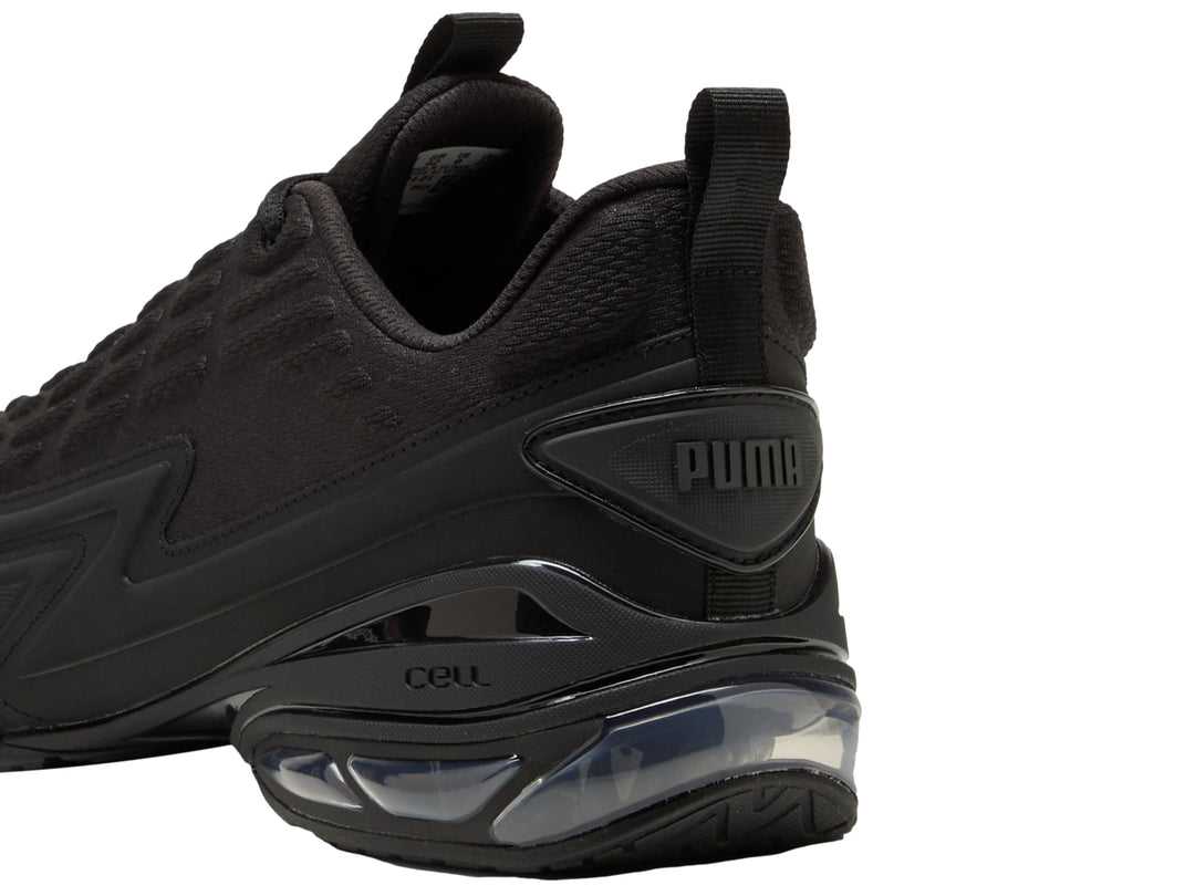 Tenis PUMA color negro con detalles en gris oscuro y cámara de aire visible en el talón.