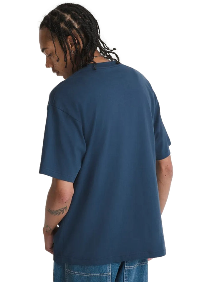 Hombre vistiendo camiseta azul marino de manga corta con estampado gráfico de un gato en el pecho.