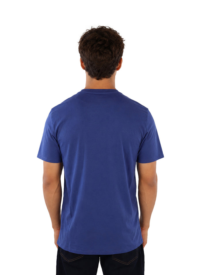 Hombre vistiendo playera azul de manga corta con estampado de Karl Lagerfeld en el pecho.