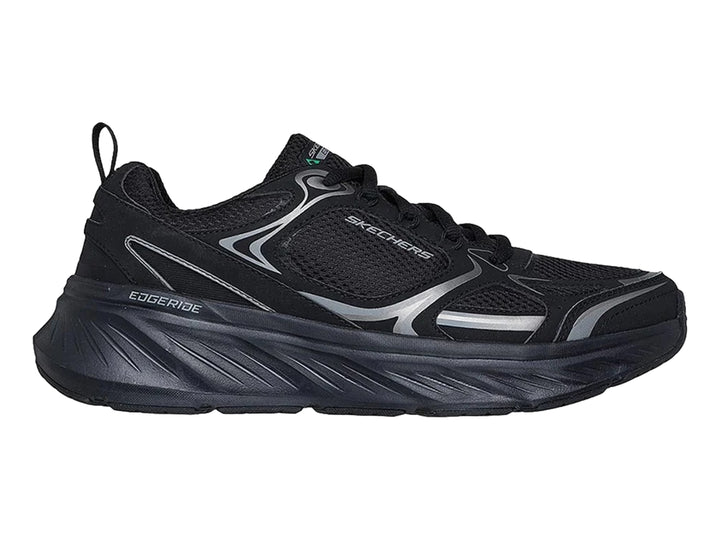 Tenis deportivos Skechers color negro con detalles en plata y suela gruesa.