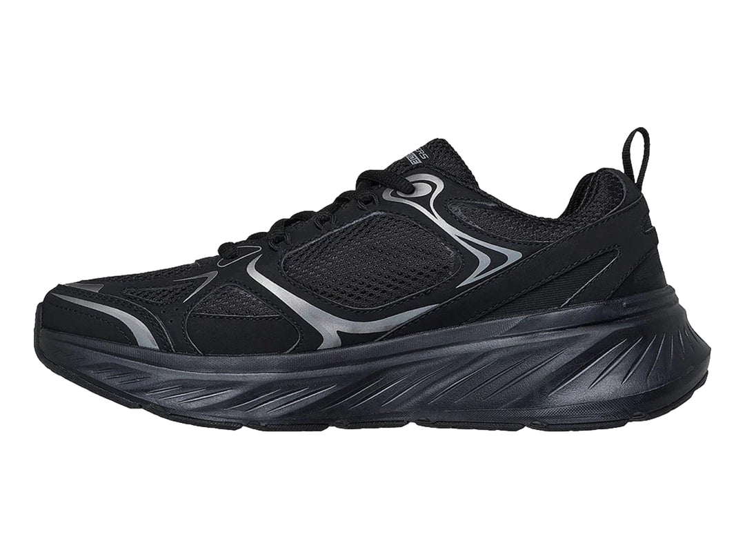 Tenis deportivos Skechers color negro con detalles en plata y suela gruesa.