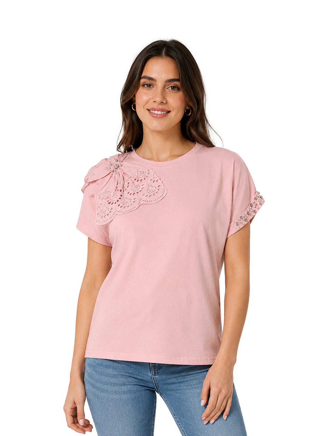 Mujer vistiendo camiseta rosa de manga corta con detalle de encaje en el hombro y jeans azules.