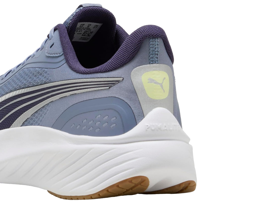 Tenis PUMA Pounce Lite en color gris cielo con detalles en morado y suela blanca gruesa.