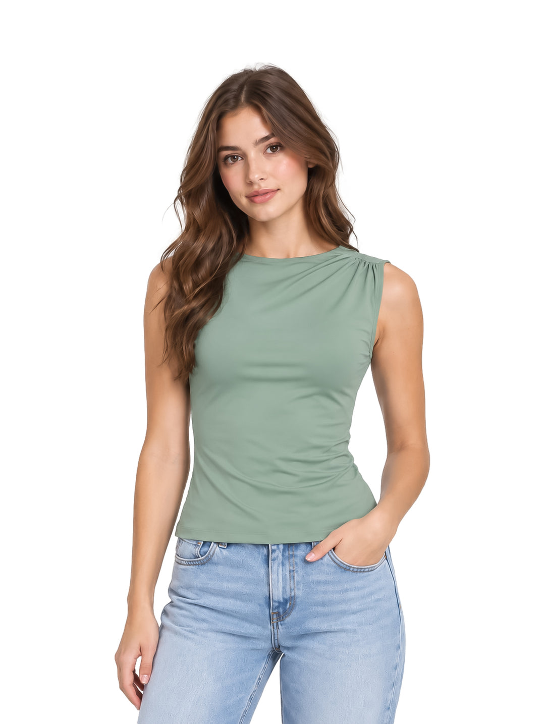 Mujer vistiendo una blusa sin mangas color verde sage y pantalones de mezclilla claros.