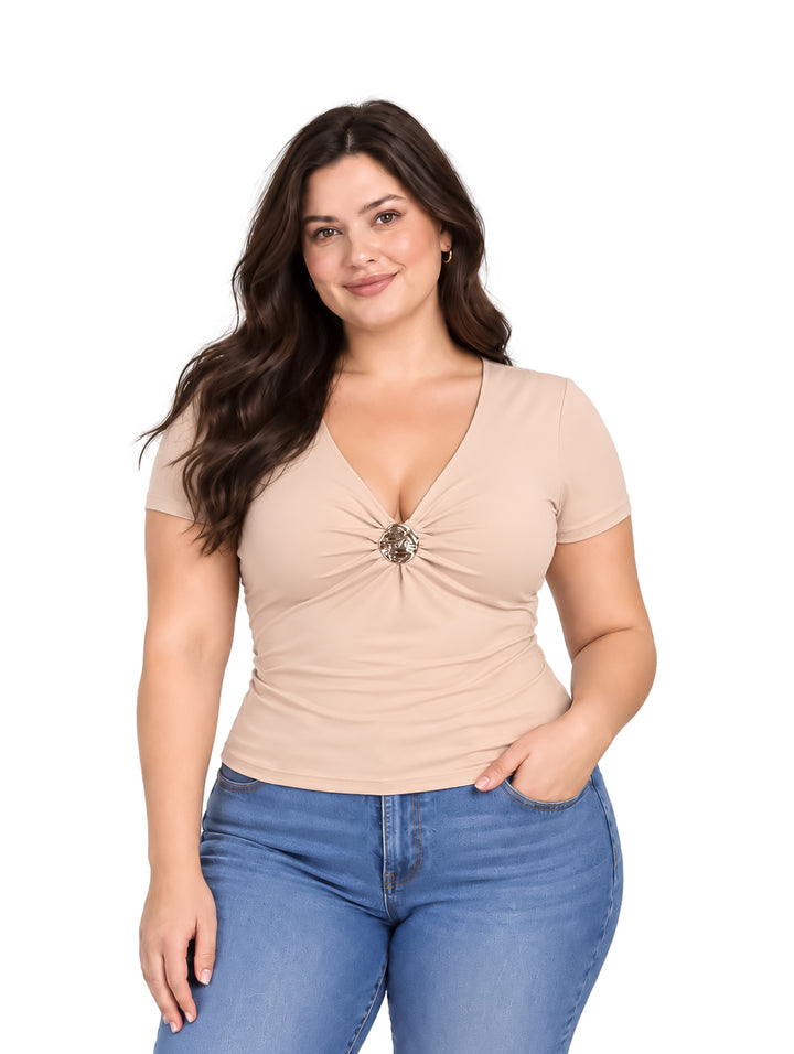 Mujer vistiendo blusa color champagne con cuello en V y detalle decorativo central.