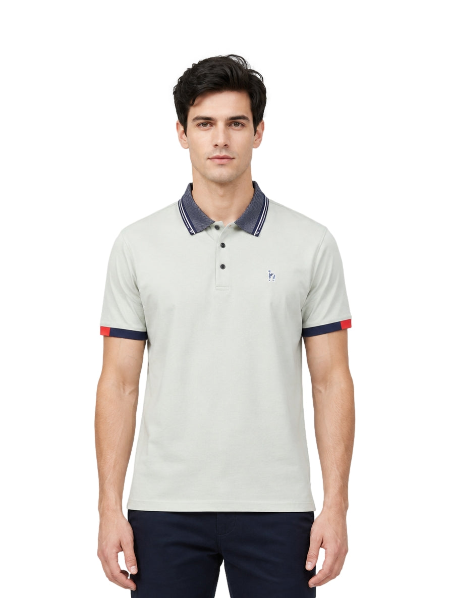 Hombre usando playera polo Pavini color verde claro con cuello y puños en azul marino y detalle rojo.