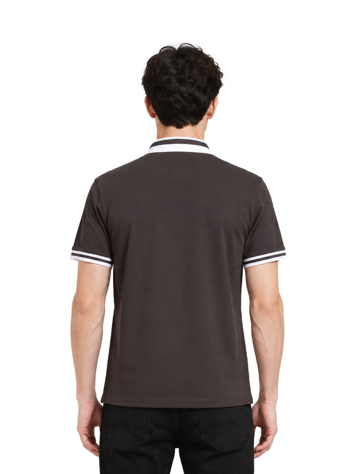 Hombre vistiendo playera polo color charcoal con detalles blancos en el cuello y los bordes de las mangas.