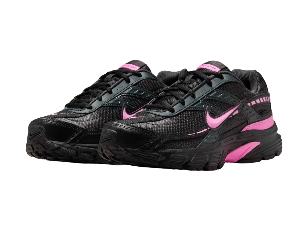 Tenis deportivos Nike color negro con detalles en rosa, vista lateral.