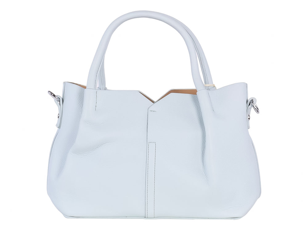 Bolso de hombro color azul claro con asa superior y un accesorio colgante de borla amarilla y blanca.