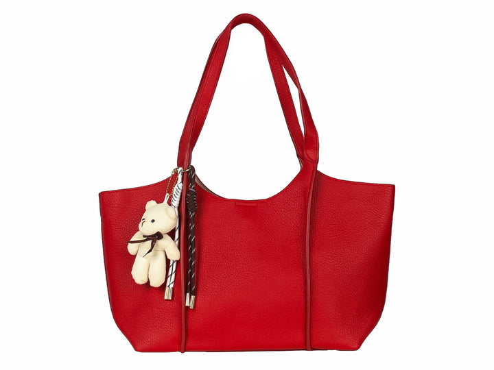 Bolsa de hombro color rojo con textura rugosa y un pequeño oso de peluche blanco como accesorio colgante.