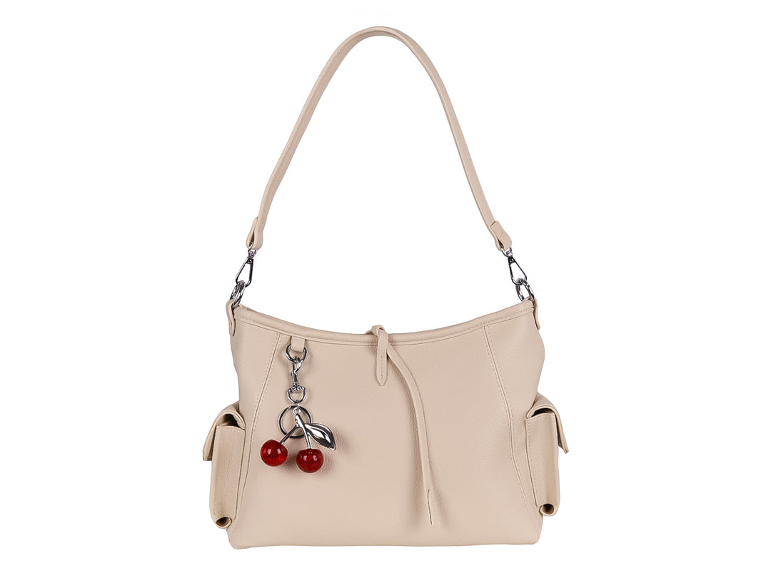 Bolsa de hombro color beige con textura lisa y un accesorio colgante en forma de cerezas rojas.