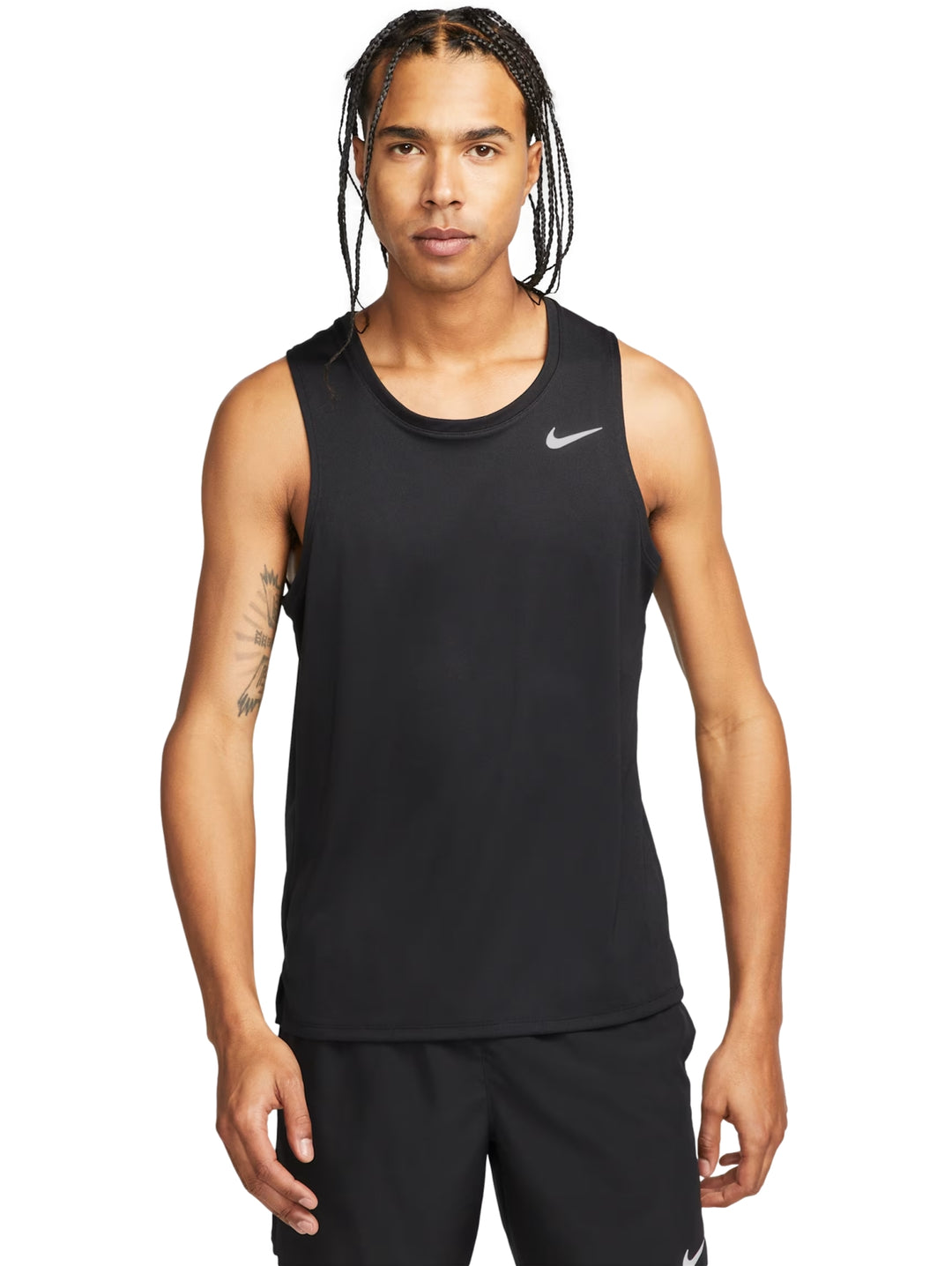 Hombre vistiendo una camiseta sin mangas Nike de color negro y pantalones cortos deportivos.