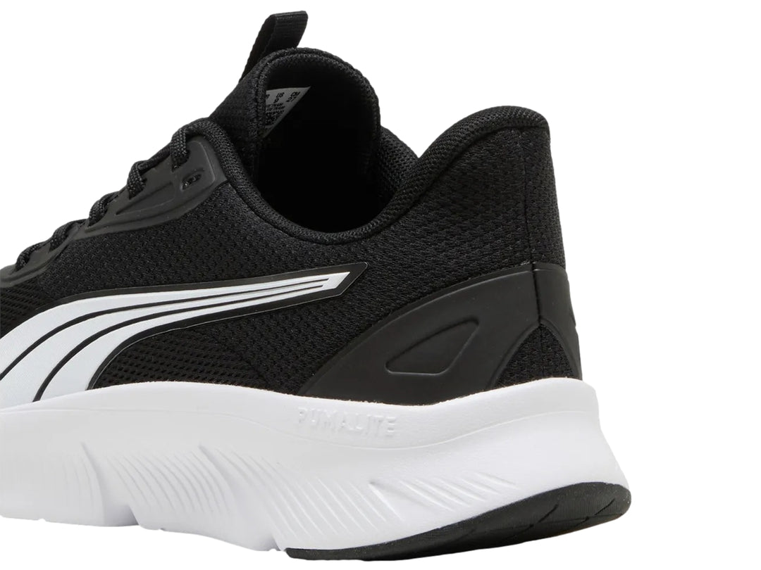 Tenis deportivos PUMA para niños en color negro con suela blanca y franja lateral blanca y plata.