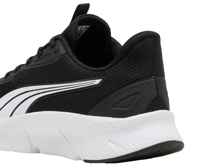 Tenis deportivos PUMA para niños en color negro con suela blanca y franja lateral blanca y plata.