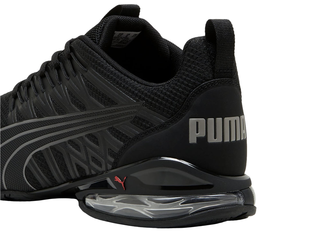 Tenis deportivos PUMA en color negro con detalles en gris y suela con cámara de aire visible.