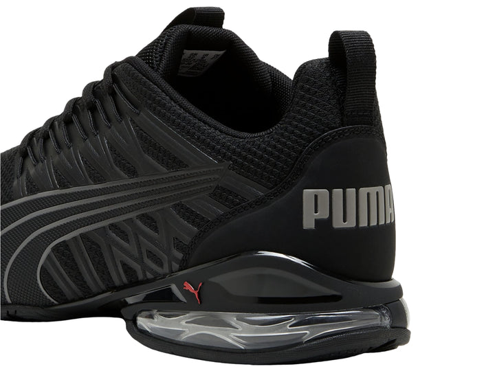 Tenis deportivos PUMA en color negro con detalles en gris y suela con cámara de aire visible.