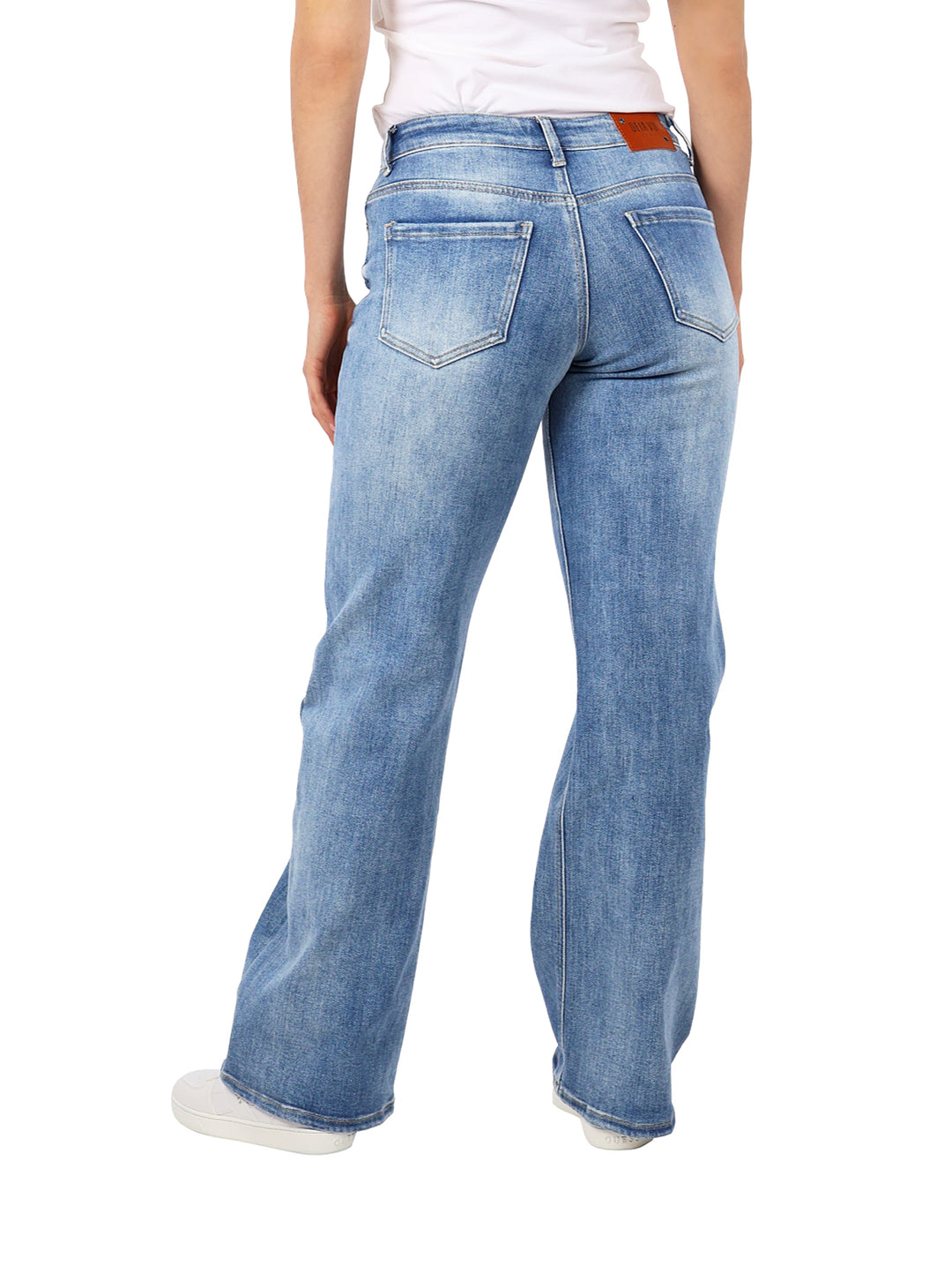 Pantalones de mezclilla azul oscuro de corte ancho con detalles de destrucción en las rodillas.