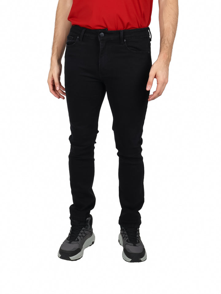 Hombre vistiendo pantalones jeans color negro de corte ajustado y camiseta roja.