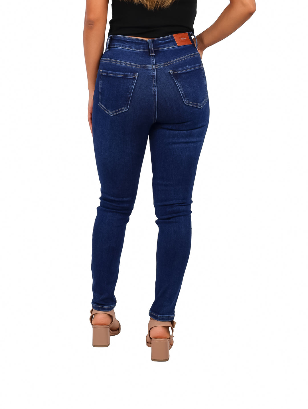 Mujer vistiendo pantalones jeans ajustados color stone oscuro.