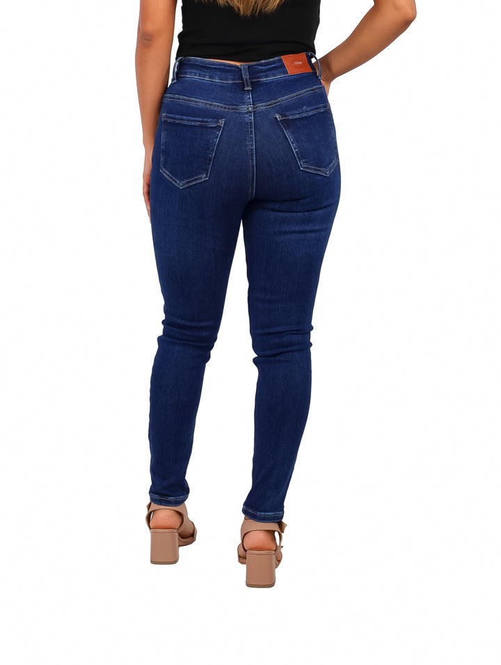 Mujer vistiendo pantalones jeans ajustados color stone oscuro.