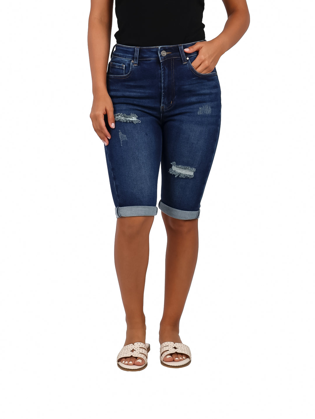Mujer vistiendo pantalón capri de mezclilla color azul oscuro con detalles desgastados.