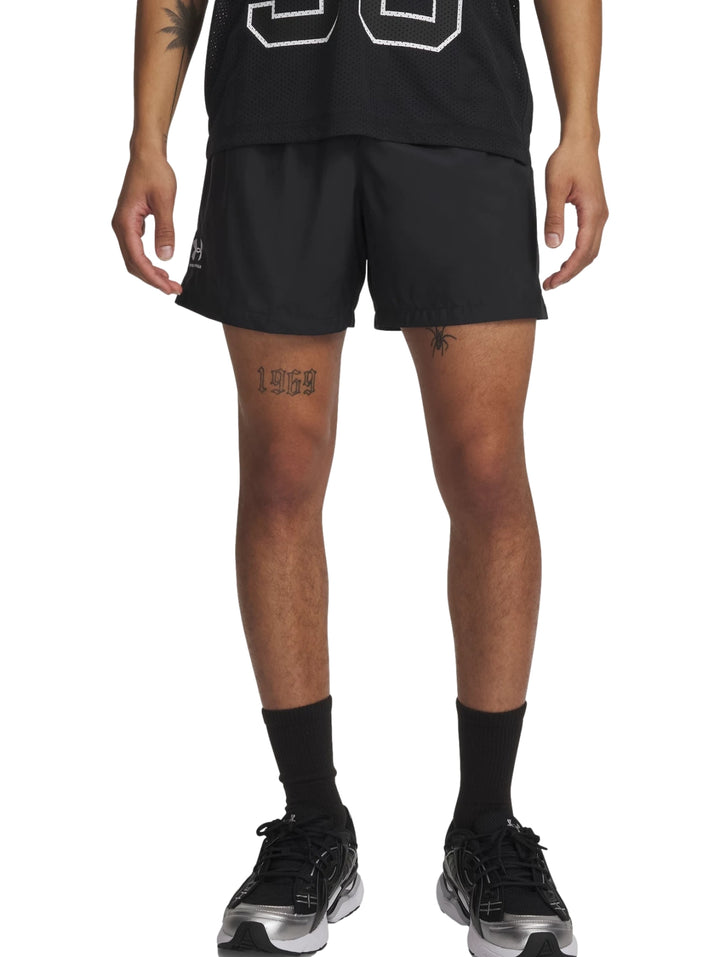 Hombre vistiendo pantalones cortos deportivos Under Armour en color negro.