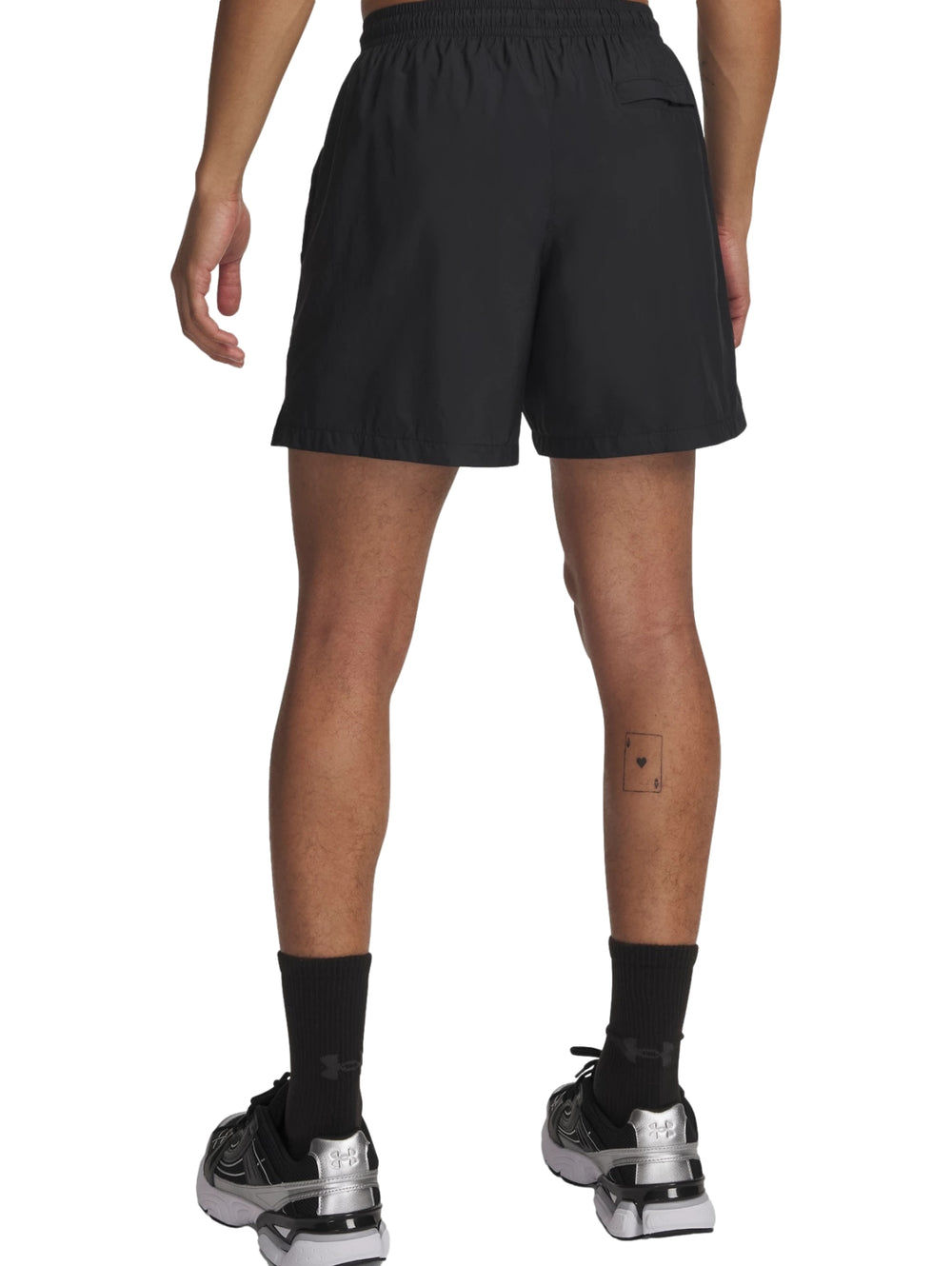 Hombre vistiendo pantalones cortos deportivos Under Armour en color negro.