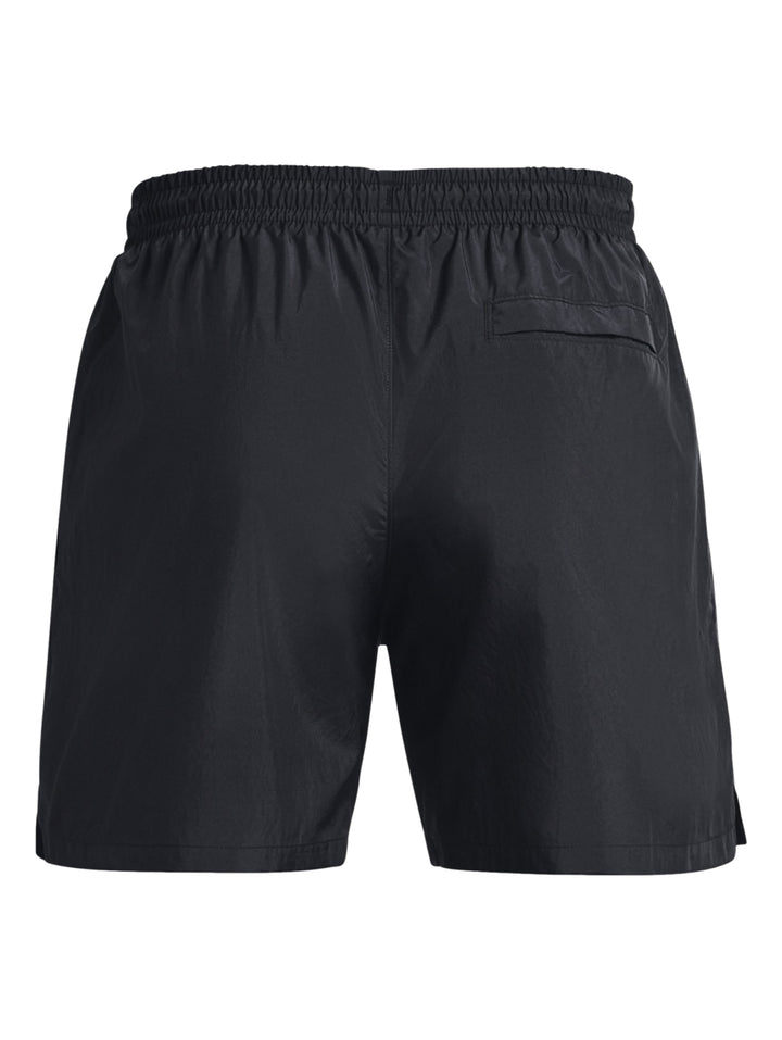 Hombre vistiendo pantalones cortos deportivos Under Armour en color negro.