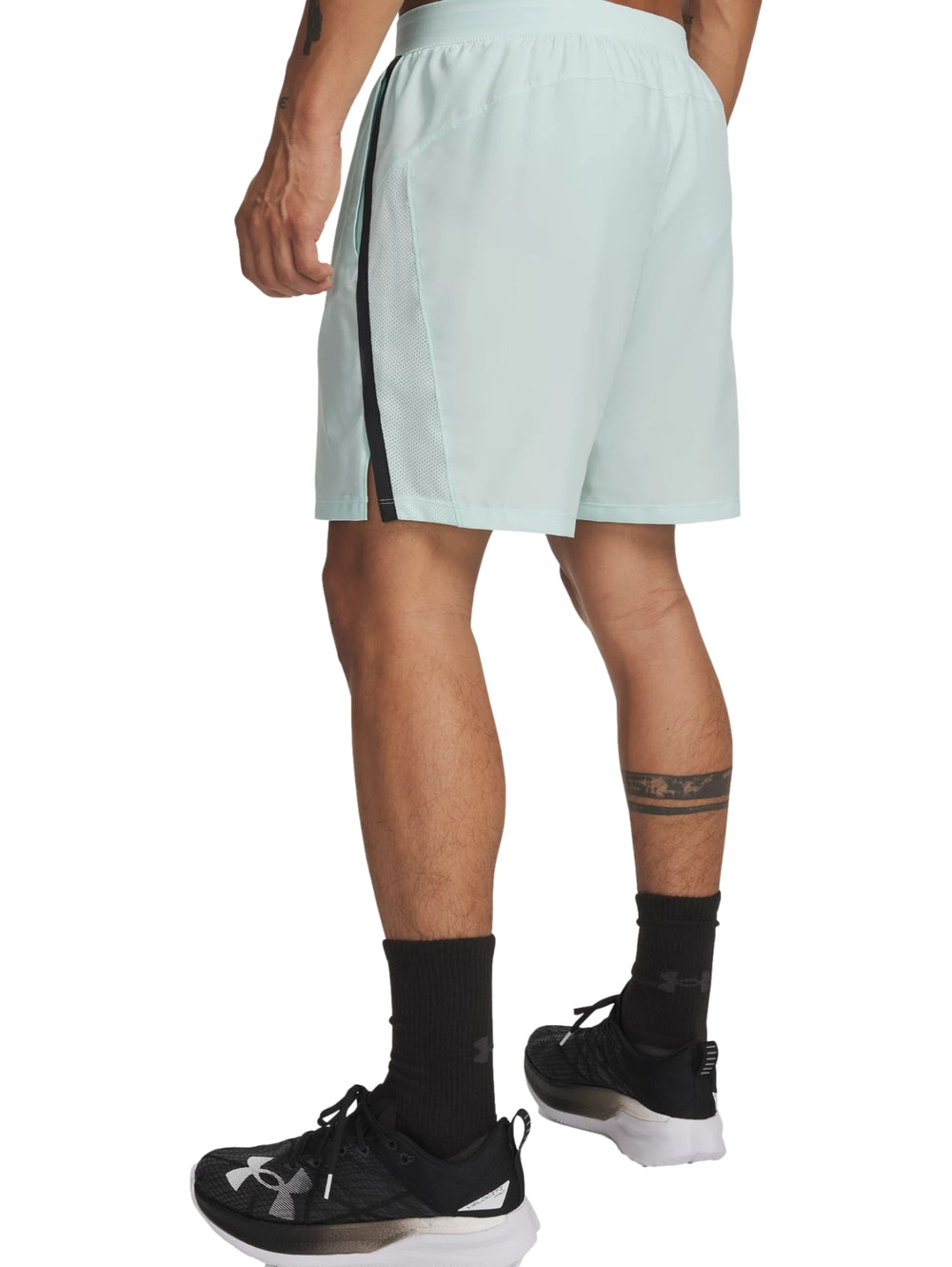 Hombre vistiendo shorts deportivos Under Armour color verde menta con franja lateral negra.