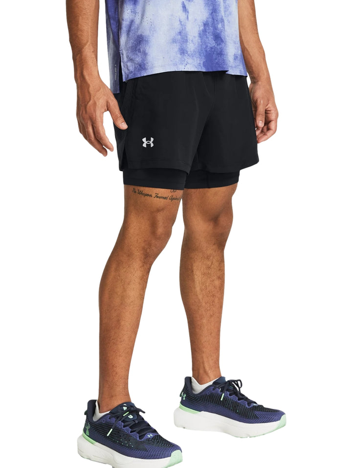 Hombre vistiendo shorts deportivos 2 en 1 de color negro marca Under Armour.