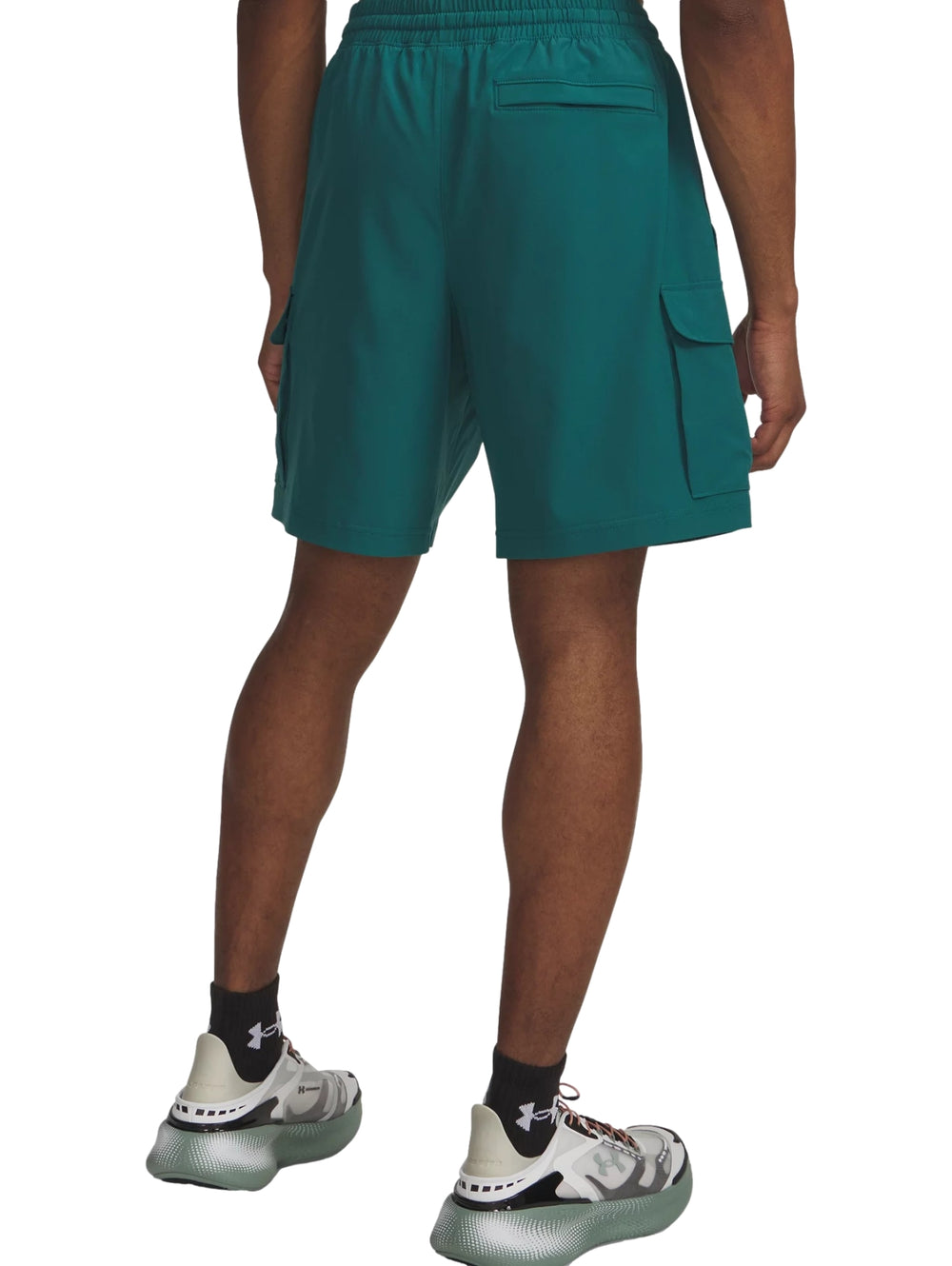 Hombre vistiendo shorts cargo color verde oscuro de la marca Under Armour.