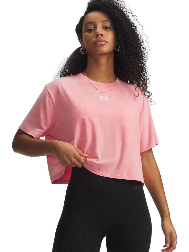 Mujer vistiendo una camiseta deportiva rosa de corte boxy de la marca Under Armour.