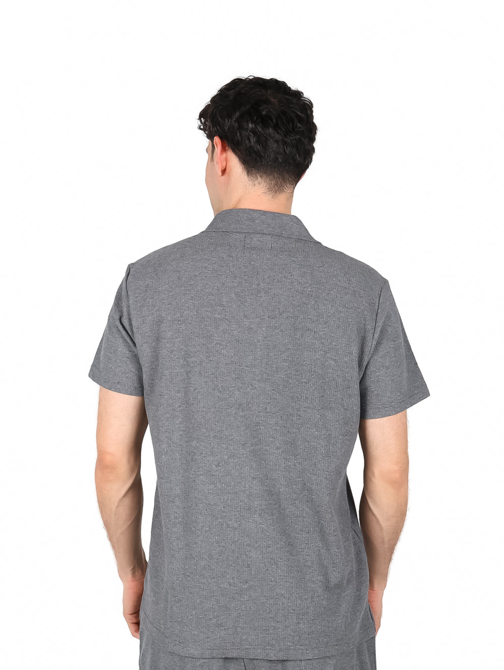 Hombre vistiendo una camisa casual de color gris oxford con botones blancos y manga corta.