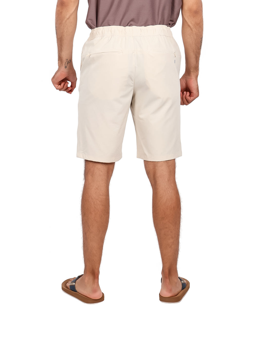 Hombre vistiendo bermudas color hueso con cintura elástica y cordón ajustable.
