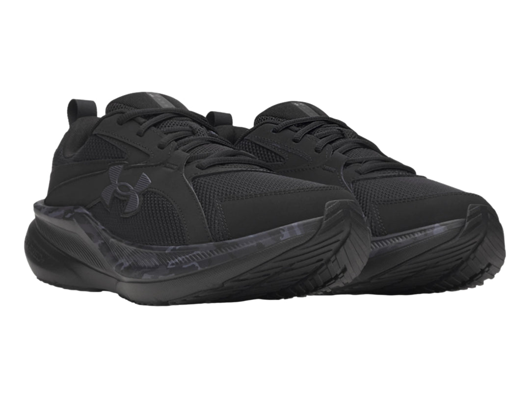 Tenis deportivos Under Armour Assert 11 en color negro con detalles de camuflaje gris en la suela.