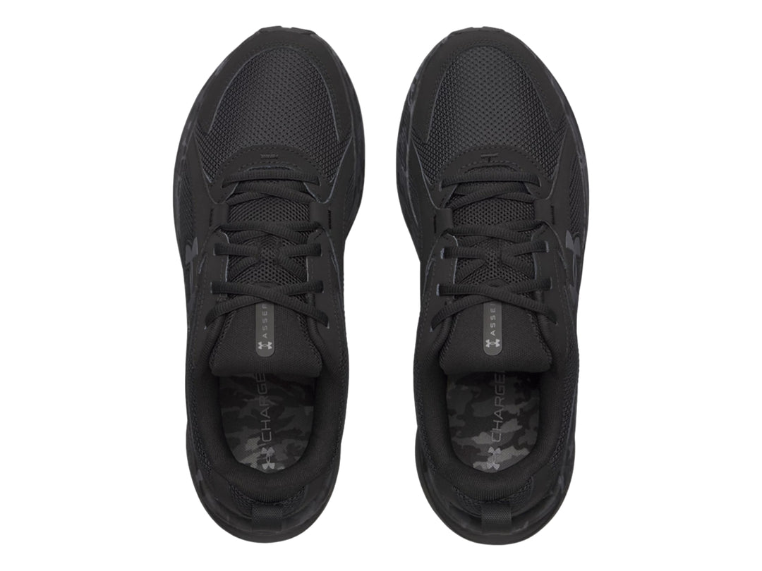 Tenis deportivos Under Armour Assert 11 en color negro con detalles de camuflaje gris en la suela.