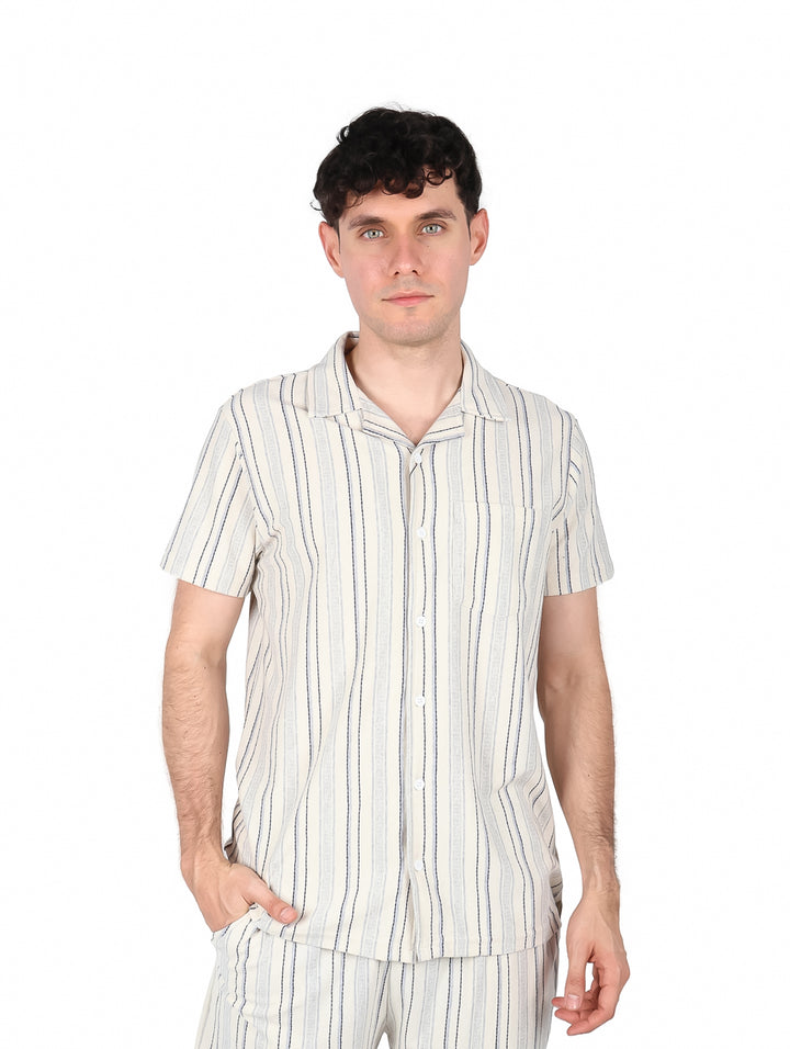 Hombre vistiendo camisa de manga corta con rayas verticales en colores azul y gris.