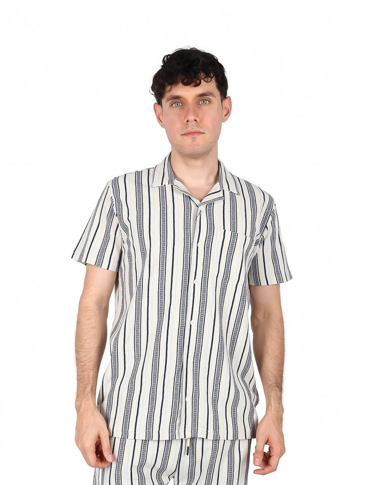 Hombre vistiendo camisa de manga corta con rayas verticales en colores marino y gris.