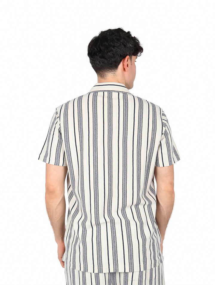 Hombre vistiendo camisa de manga corta con rayas verticales en colores marino y gris.