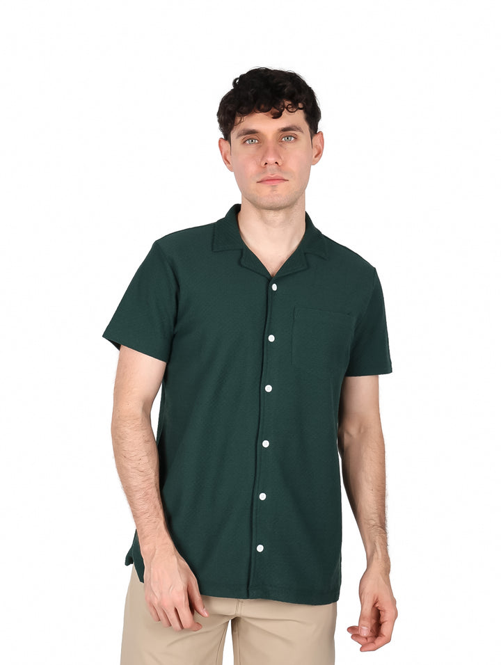 Hombre vistiendo una camisa de manga corta color olivo con botones frontales.