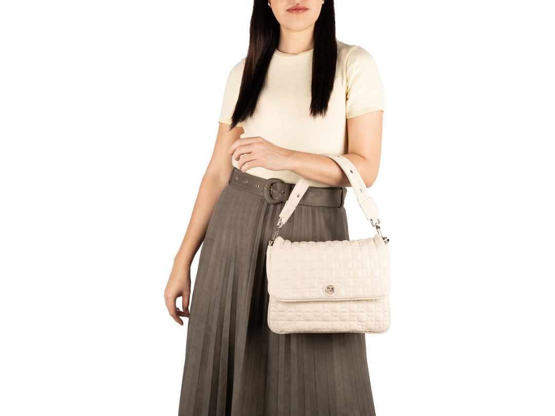 Bolso de hombro Cloe color beige con textura acolchada y correa ajustable.