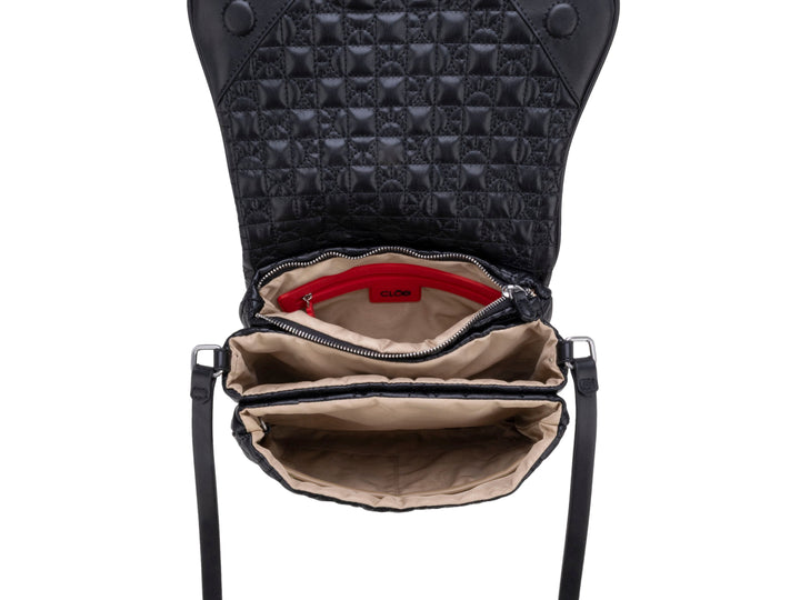 Bolso de hombro color negro con textura acolchada geométrica, correa ajustable y detalle circular central.