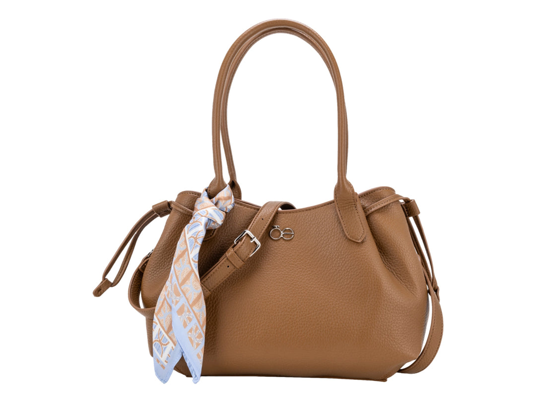 Bolsa de hombro Cloe color camel en cuero granulado con un pañuelo azul y blanco amarrado al asa.