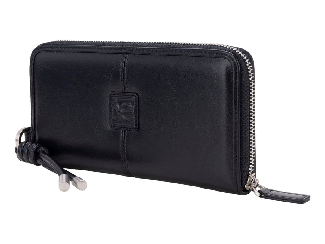 Cartera Cloe de cuero color negro con cierre perimetral y colgante decorativo.