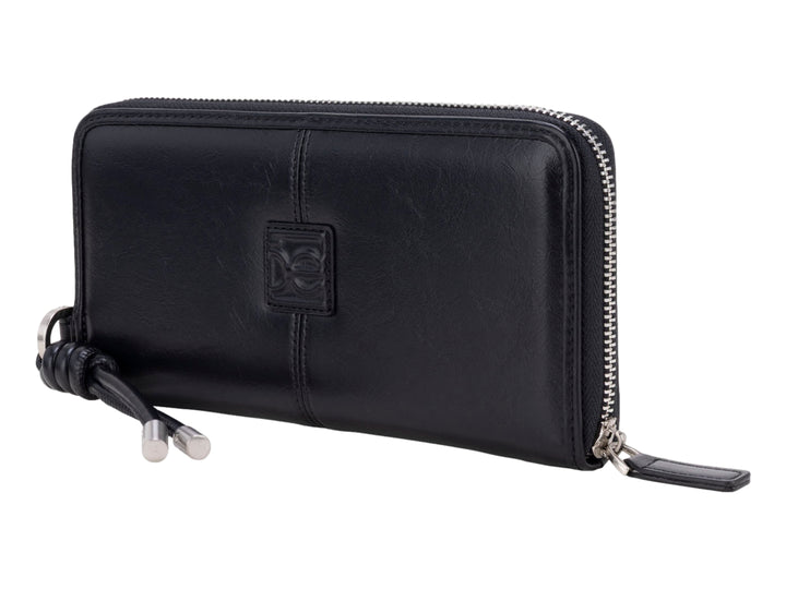 Cartera Cloe de cuero color negro con cierre perimetral y colgante decorativo.