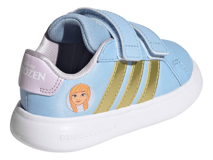 Tenis Adidas para niña en color azul claro con franjas doradas, cierre de velcro y suela blanca.