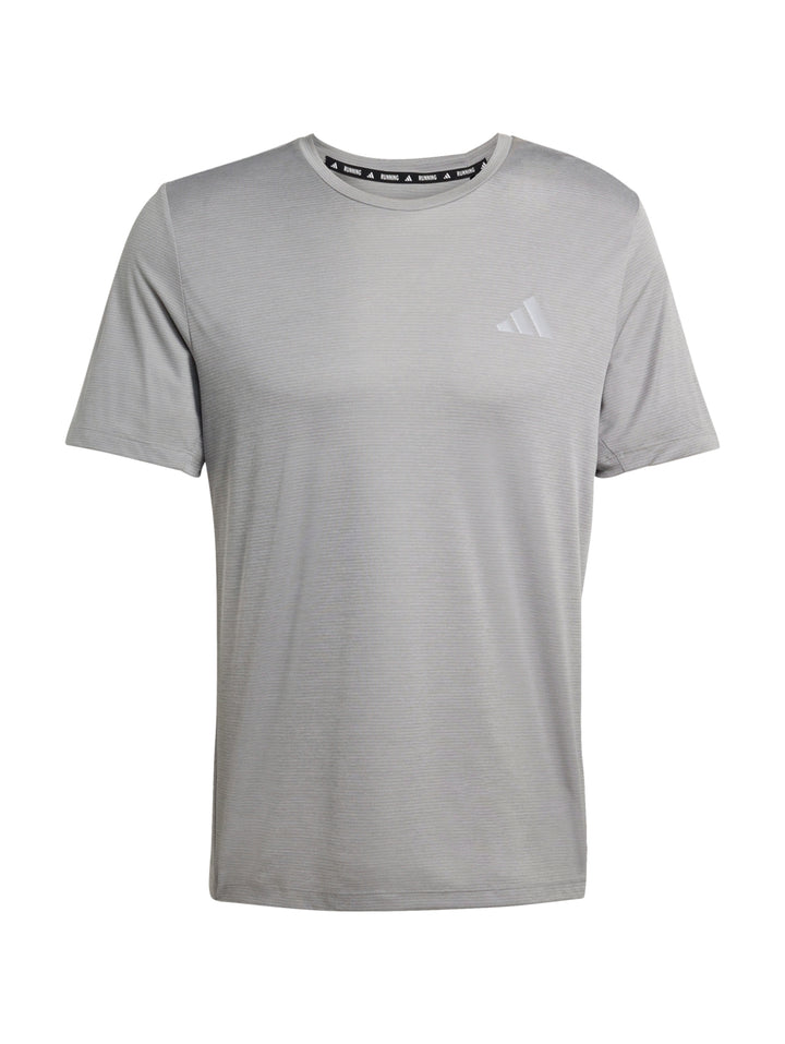 Hombre vistiendo una camiseta deportiva Adidas de color gris jaspeado de manga corta.