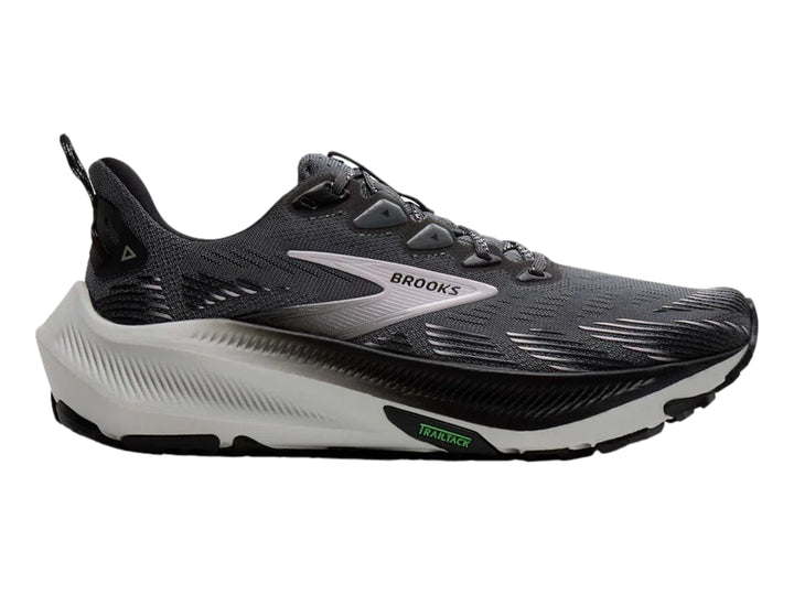 Tenis de trail running Brooks en color gris oscuro con suela blanca y detalles en negro.