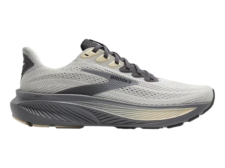 Tenis deportivos Brooks en color gris vaporoso con detalles en beige y suela gris oscuro.