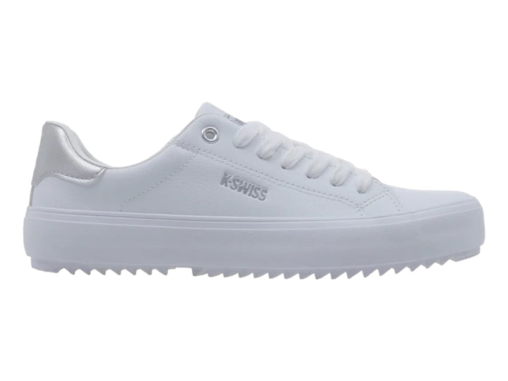 Tenis blancos K-Swiss con detalle plateado en el talón y suela blanca dentada.